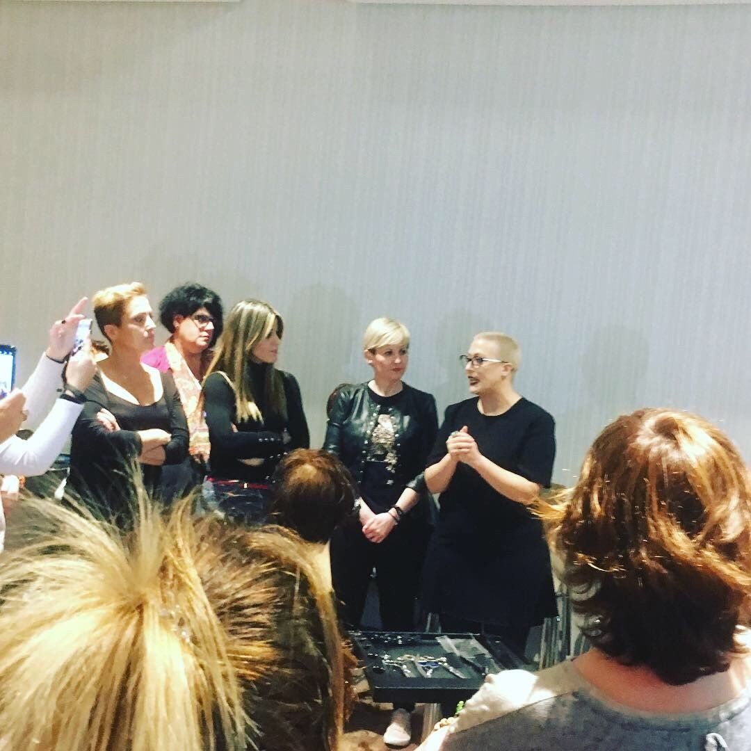 Un grupo de mujeres están de pie en una habitación hablando entre sí.