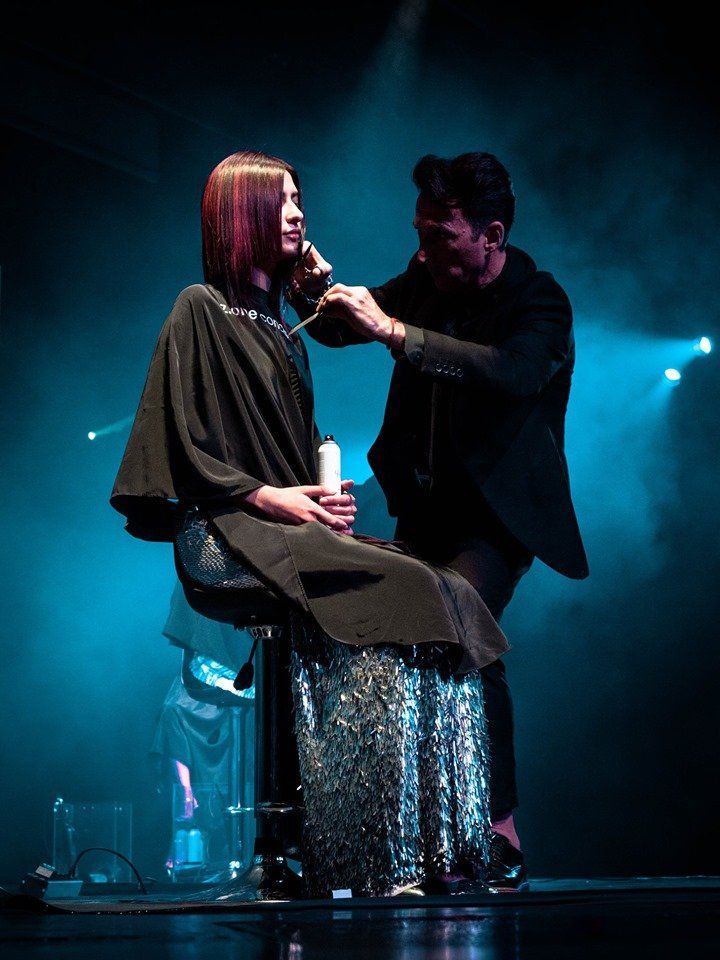 Una mujer se está cortando el pelo en un peluquero en un escenario.