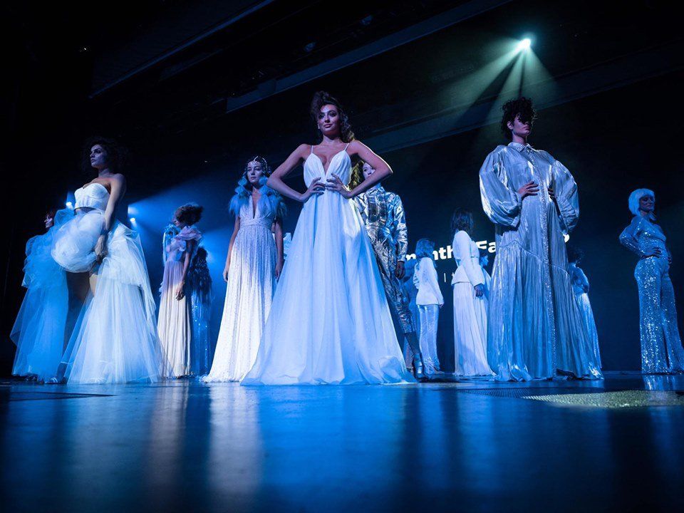 Un grupo de mujeres con vestidos blancos están de pie en un escenario.