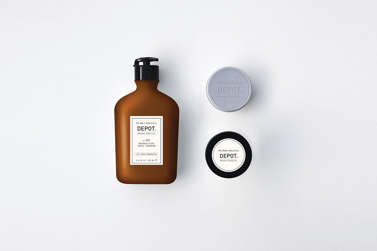 Una botella de loción y un jabón están sobre una superficie blanca.