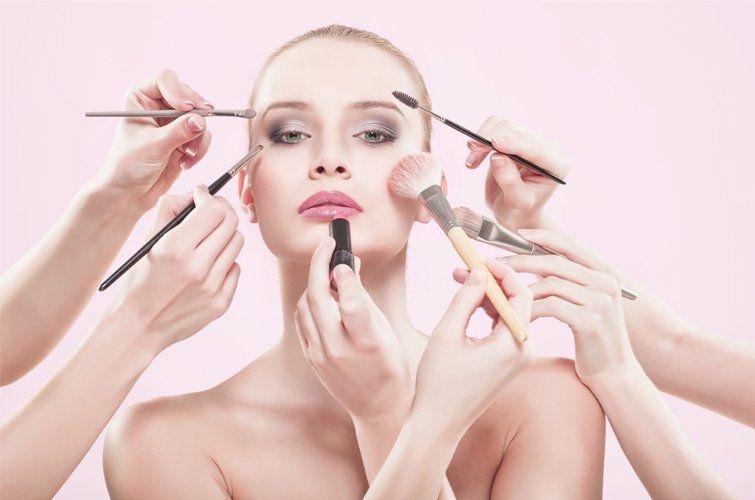 Una mujer se está maquillando con muchas manos.