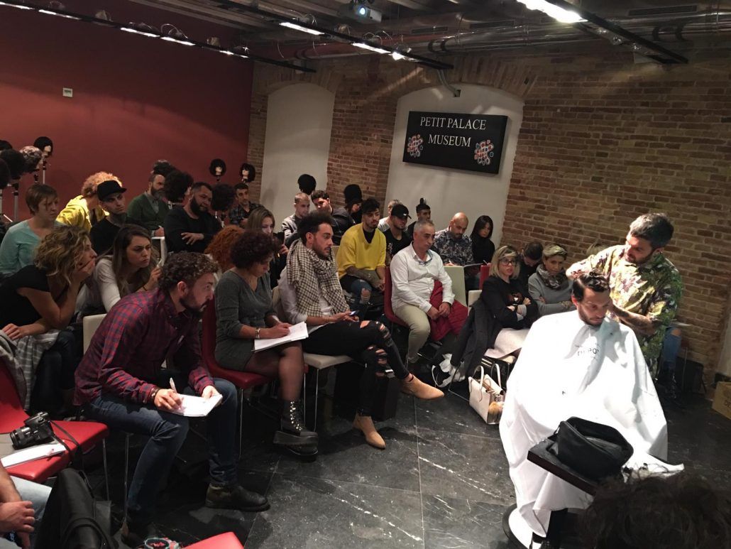 Un hombre se está cortando el pelo delante de una multitud de personas.