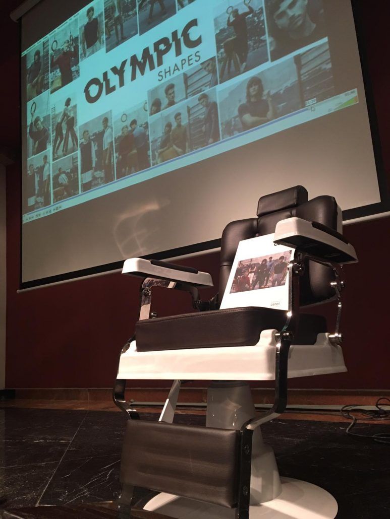 Una silla de barbero frente a una pantalla que dice olímpico