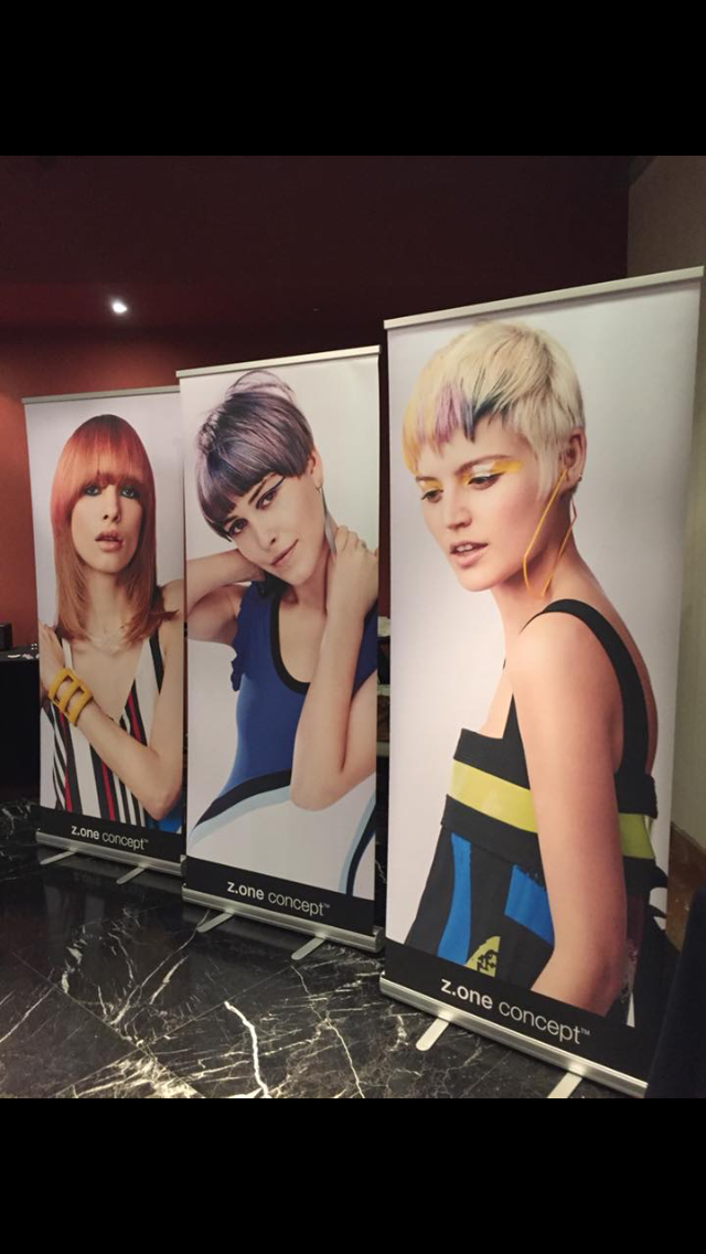 Tres carteles de mujeres con diferentes colores de pelo están alineados sobre una mesa.