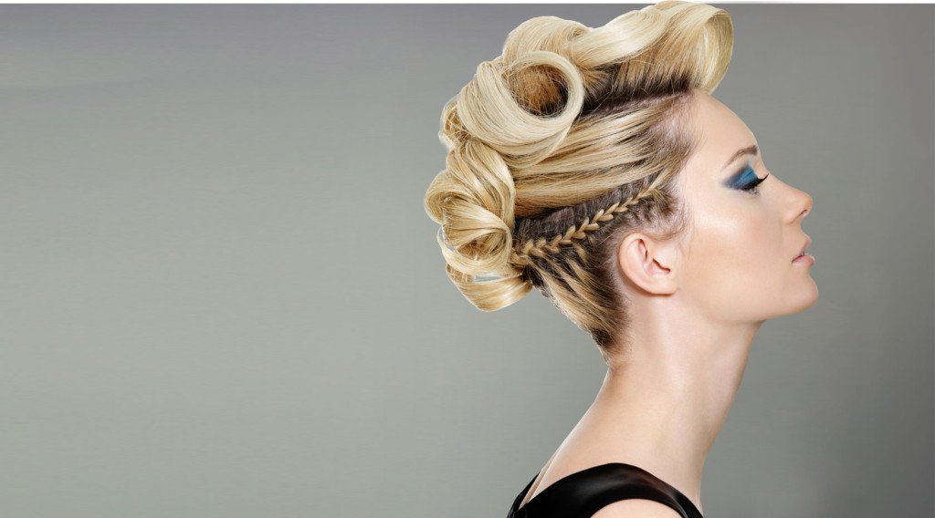 Una mujer con un peinado mohawk lleva un vestido negro.