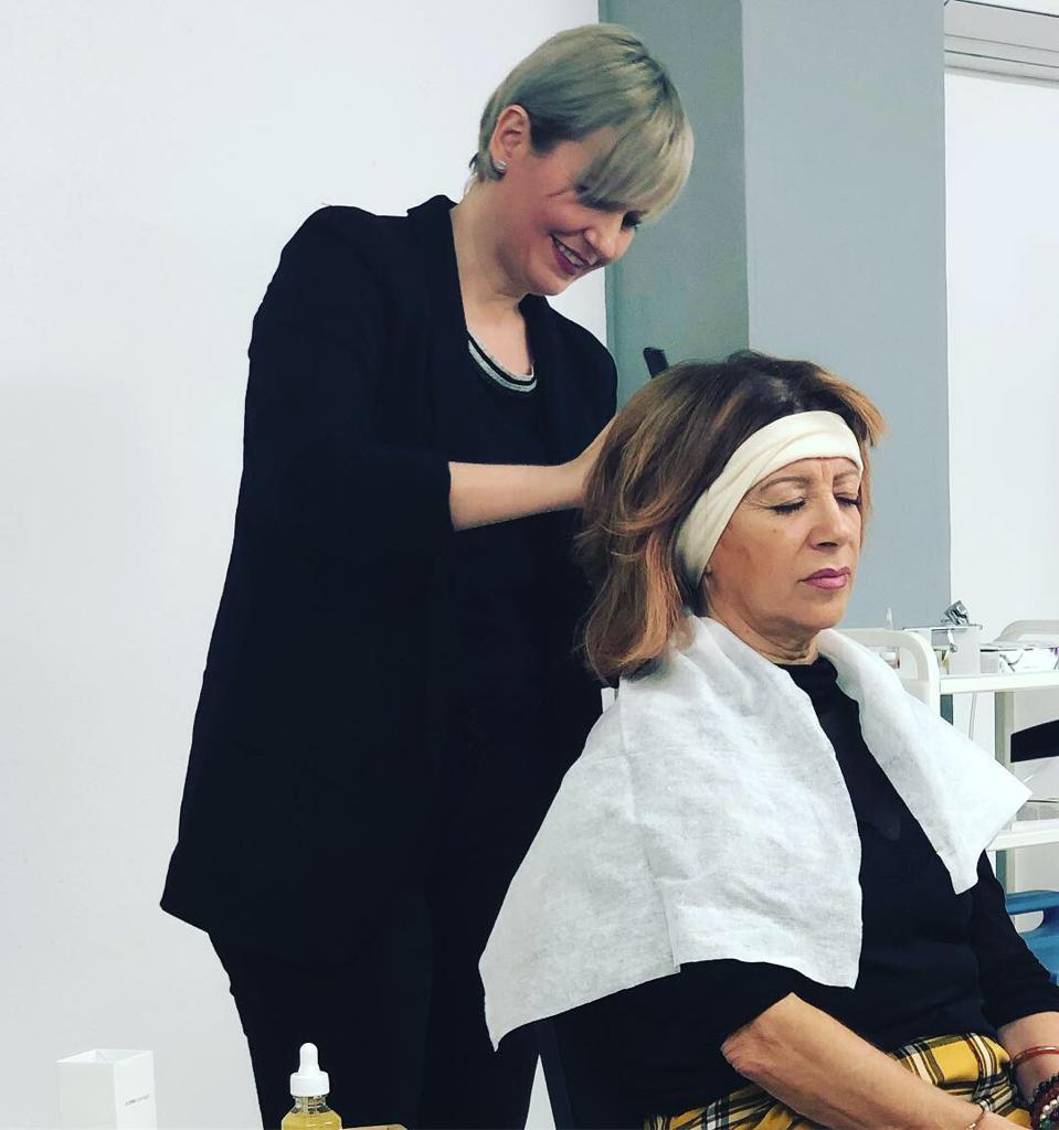 Una mujer se está cortando el pelo con otra mujer