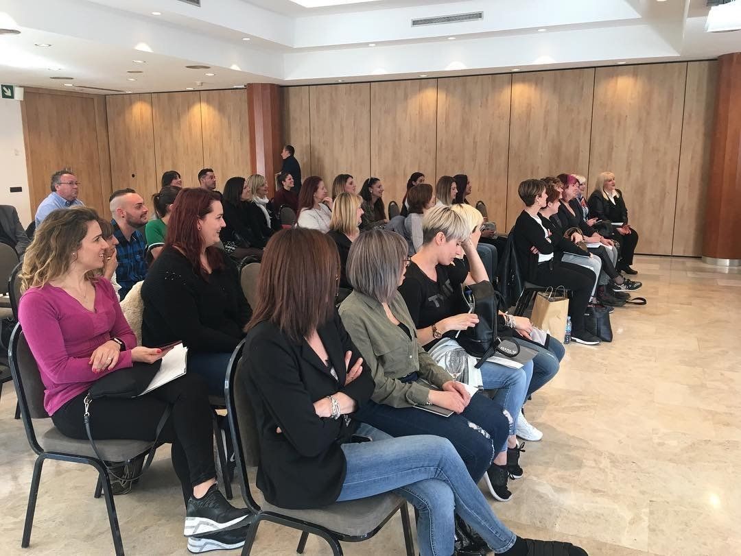 Un grupo de personas están sentadas en sillas en una habitación.