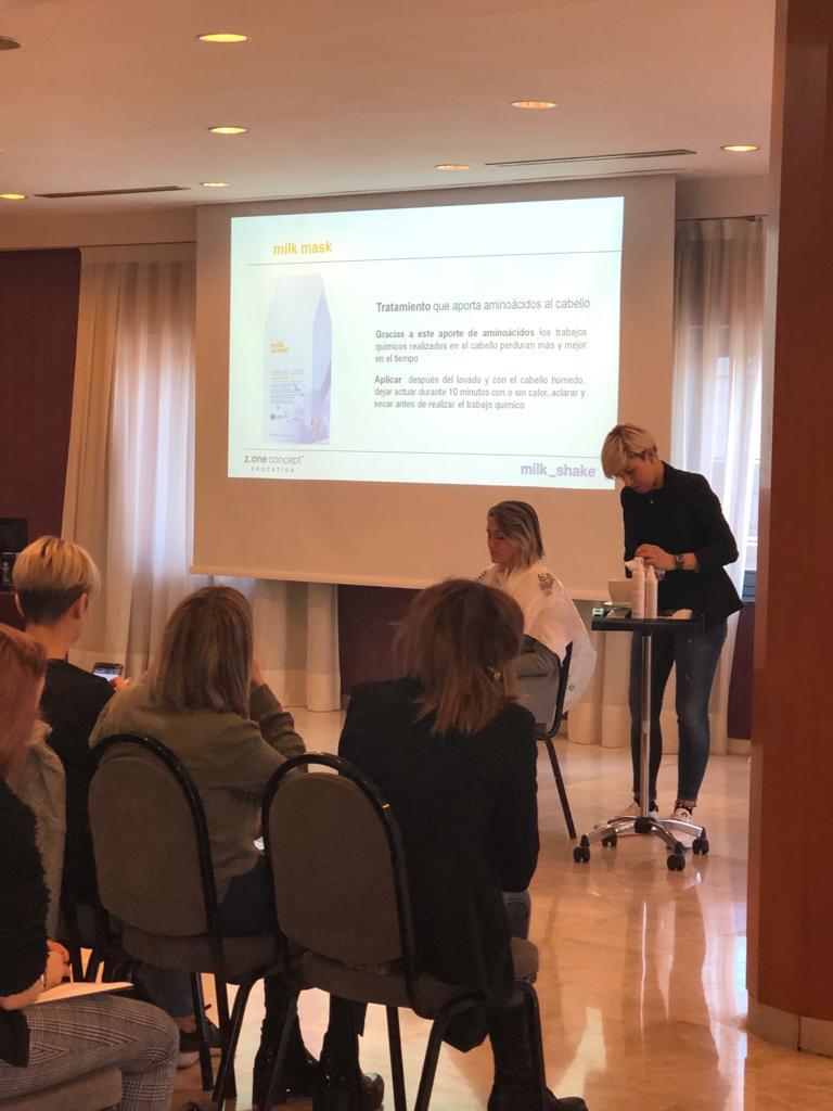 Una mujer está dando una presentación a un grupo de personas sentadas en sillas.