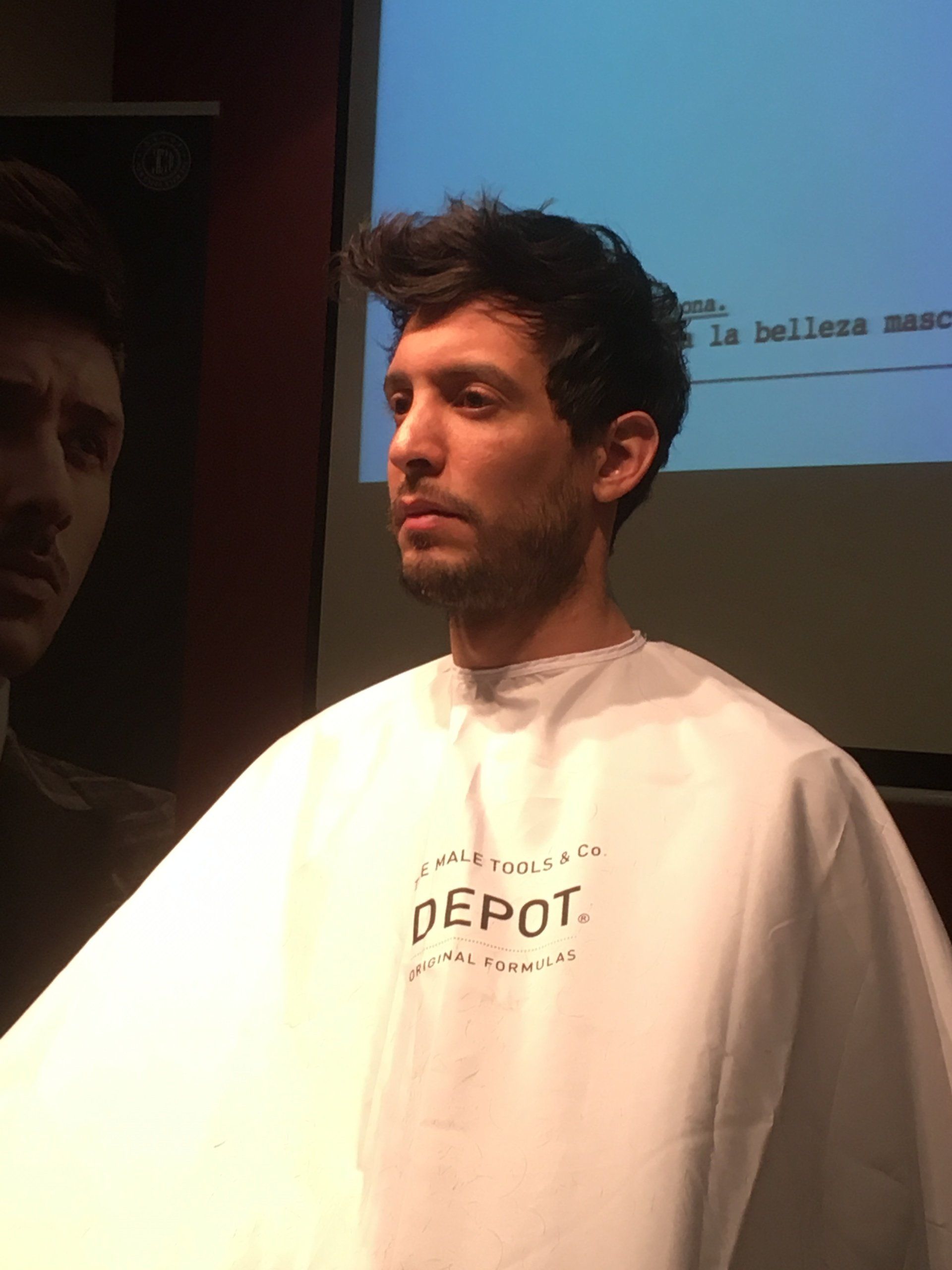 Un hombre que lleva una capa blanca con la palabra depósito escrita en ella.