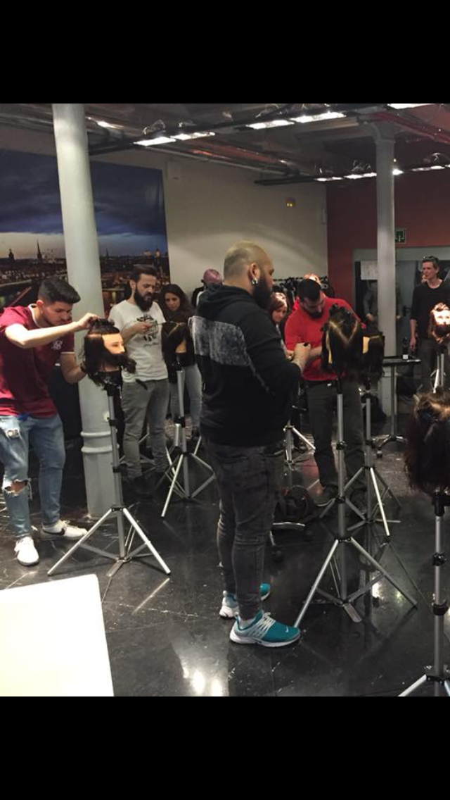 Un grupo de personas están de pie en una habitación con trípodes.