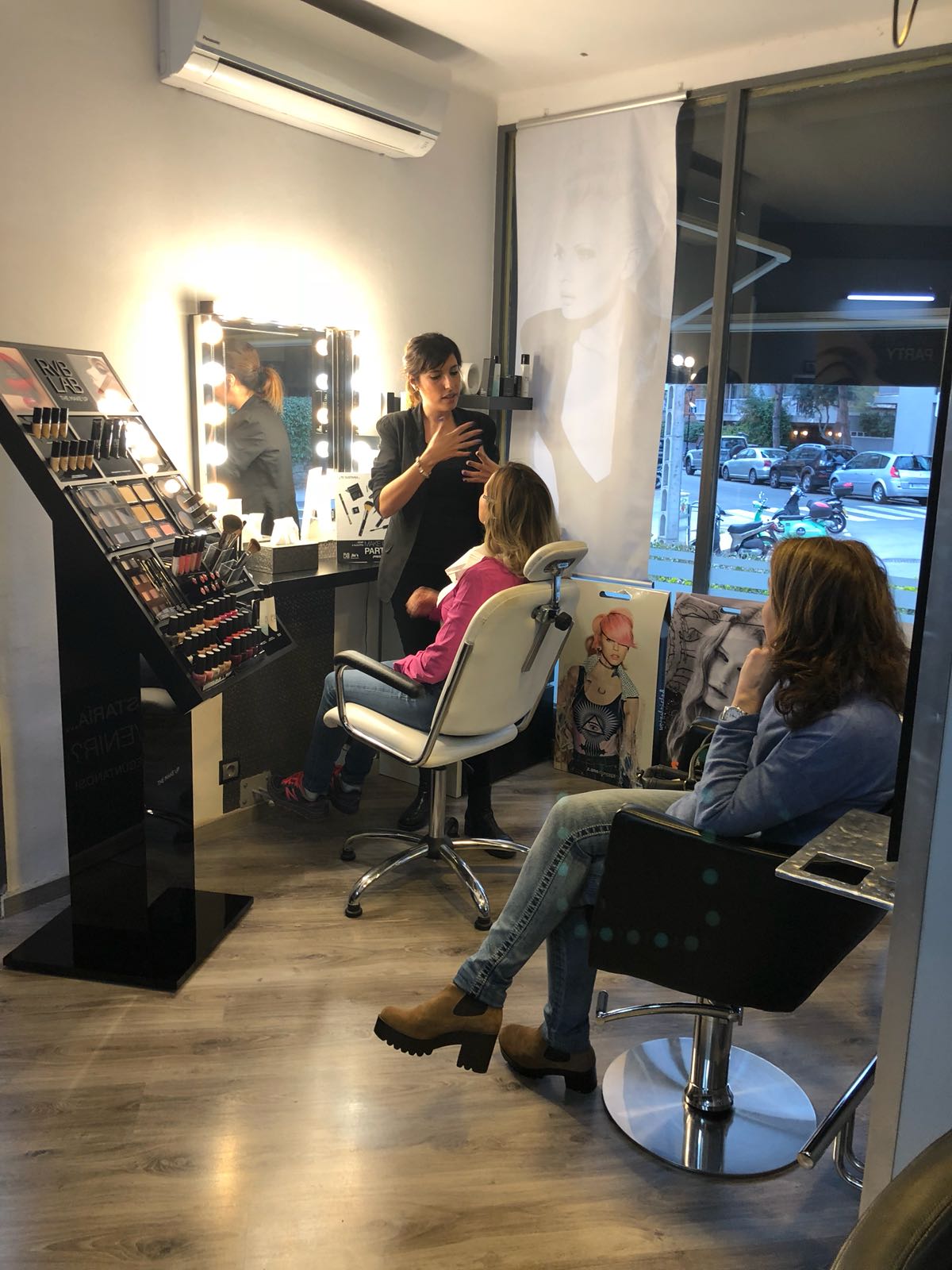 Una mujer está sentada en una silla mientras le peinan en un salón.