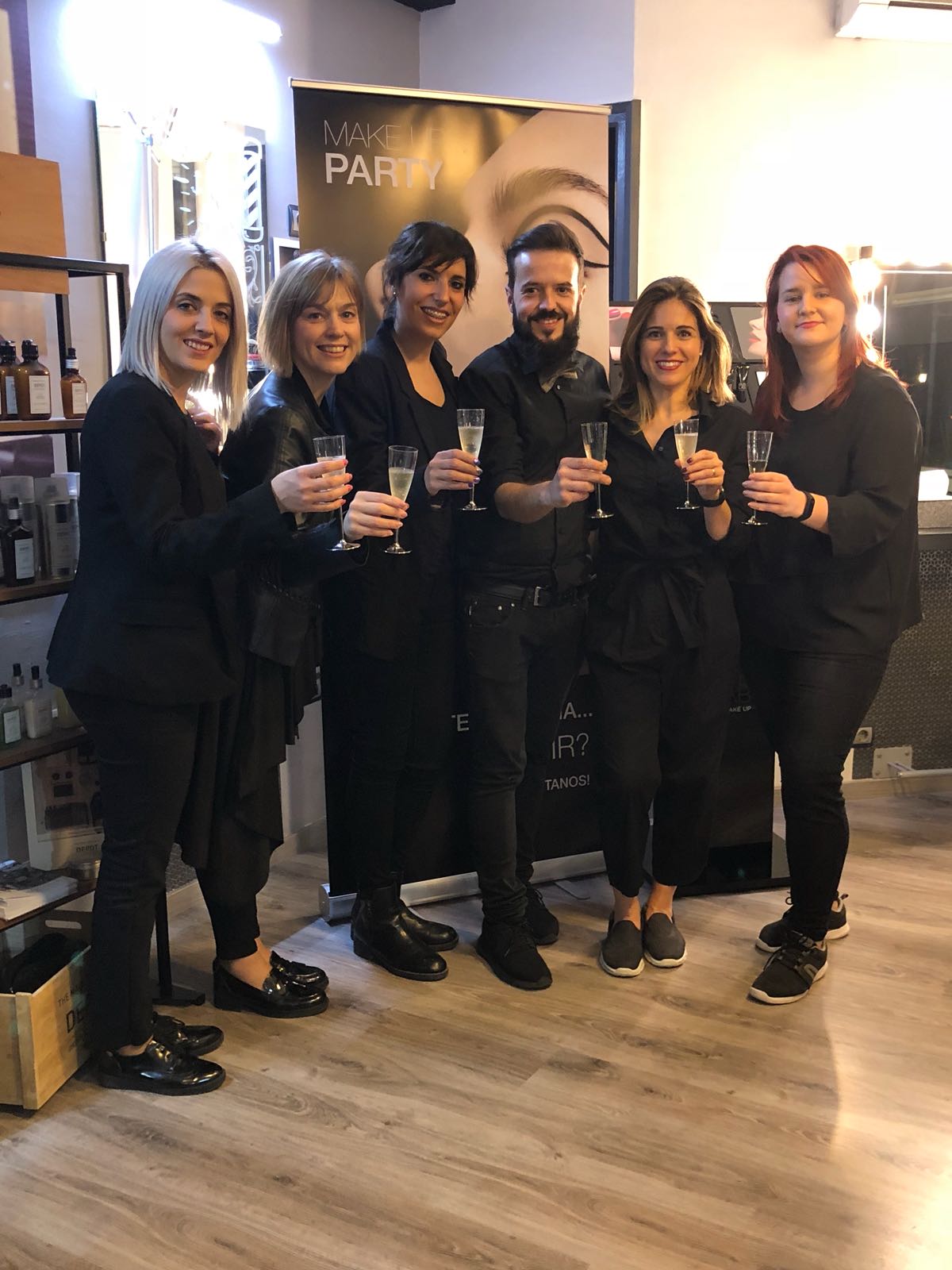 Un grupo de personas de pie en una habitación sosteniendo copas de champán.