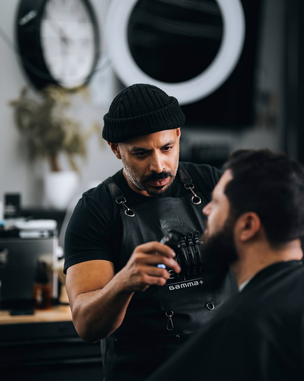 A man is getting his beard shaved by a barber.