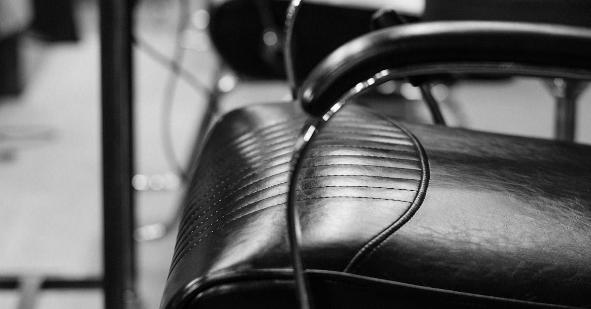 A black and white photo of a chair with a cord hanging off of it.