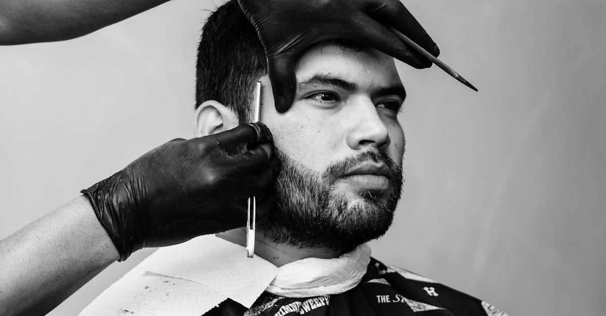 A man is getting his beard shaved by a barber.