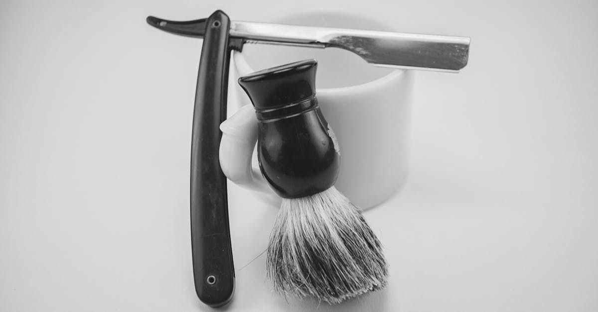 A razor and a shaving brush are in a cup.