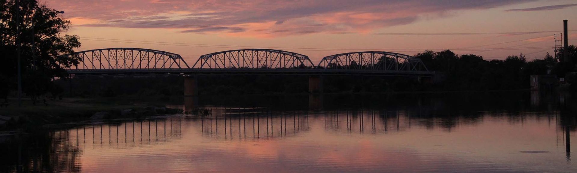 A bridge over a body of water at sunset