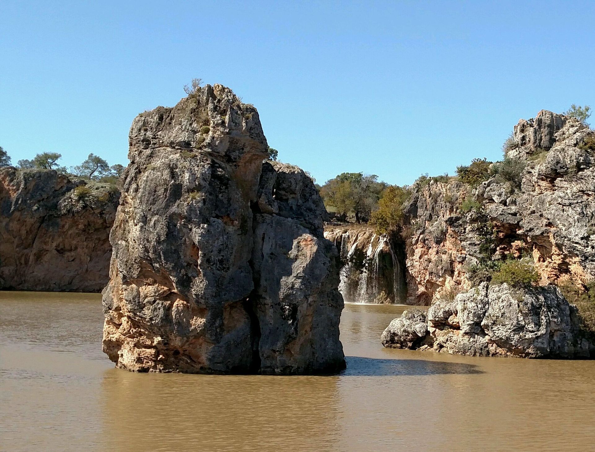 A large rock in the middle of a body of water