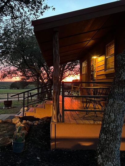 A porch of a house with a sunset in the background