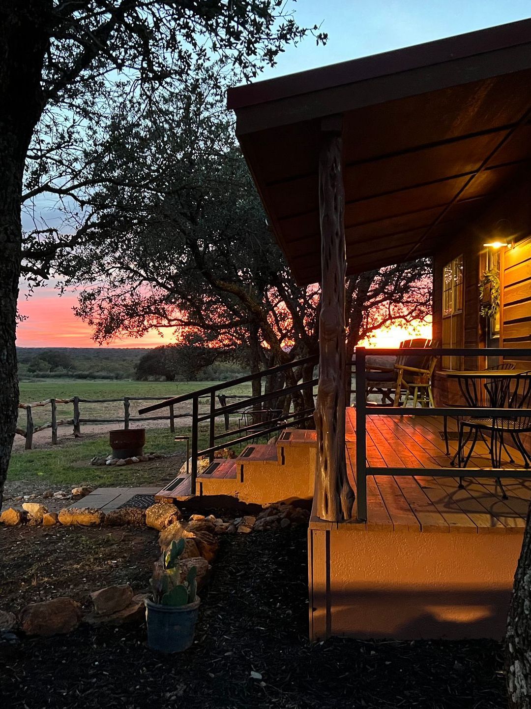 A house with a porch and a sunset in the background