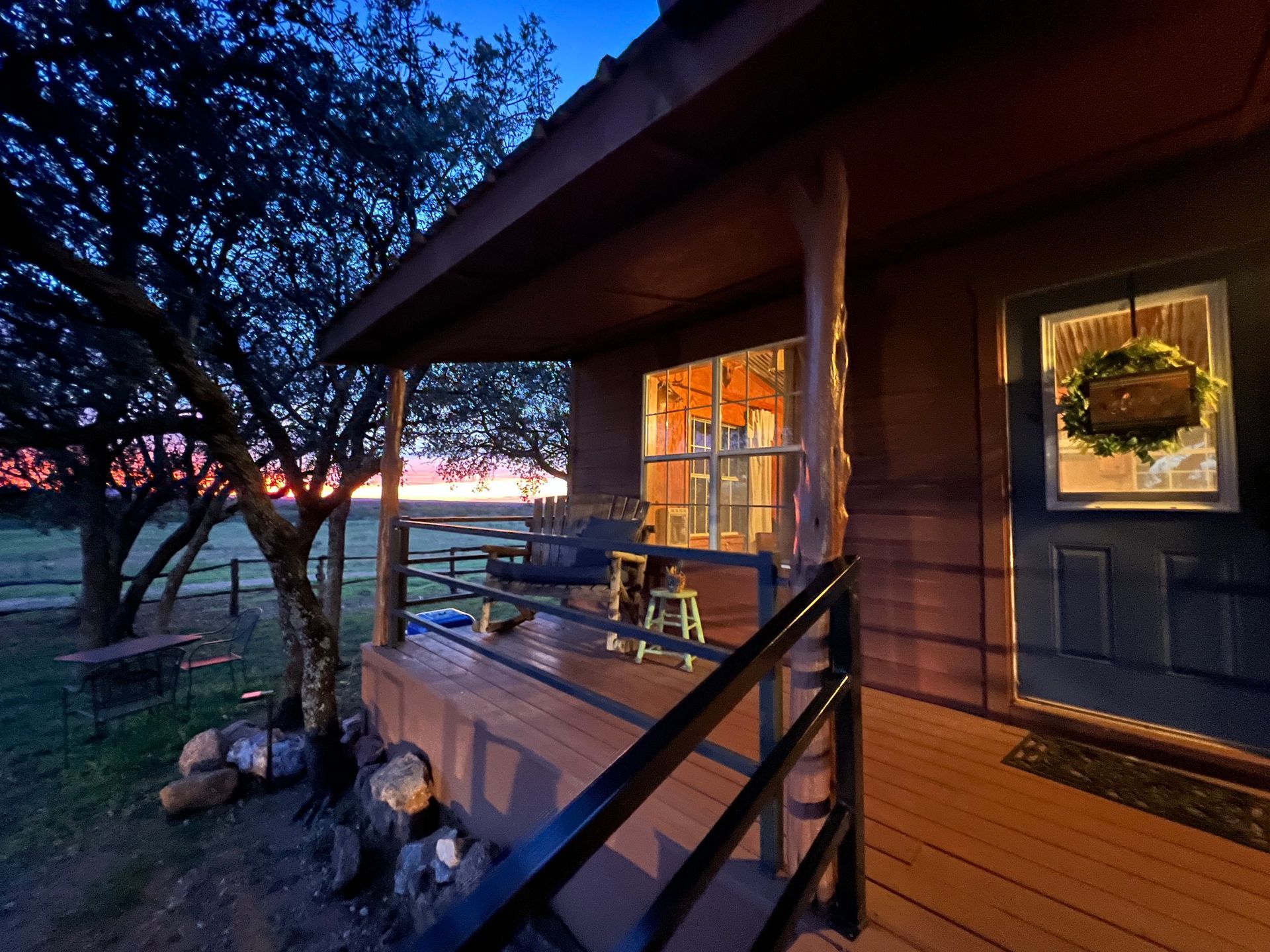 A house with a porch and a sunset in the background