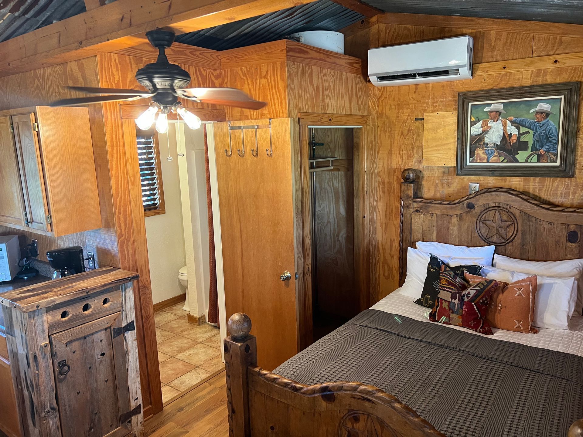 A bedroom with a bed and a ceiling fan.