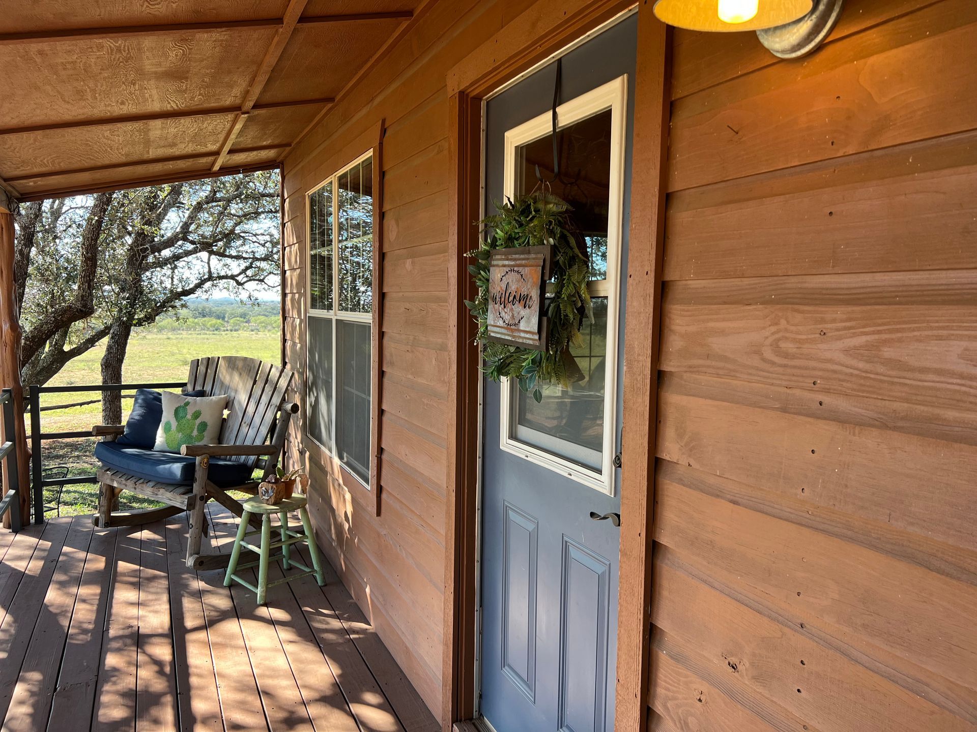 There is a porch with a swing and a blue door.