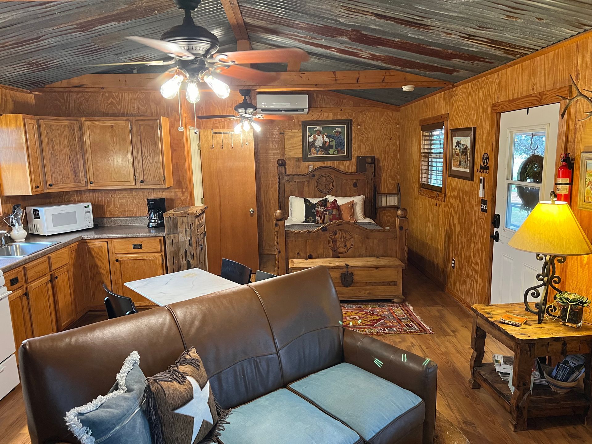 A living room with a couch , table , and ceiling fan.