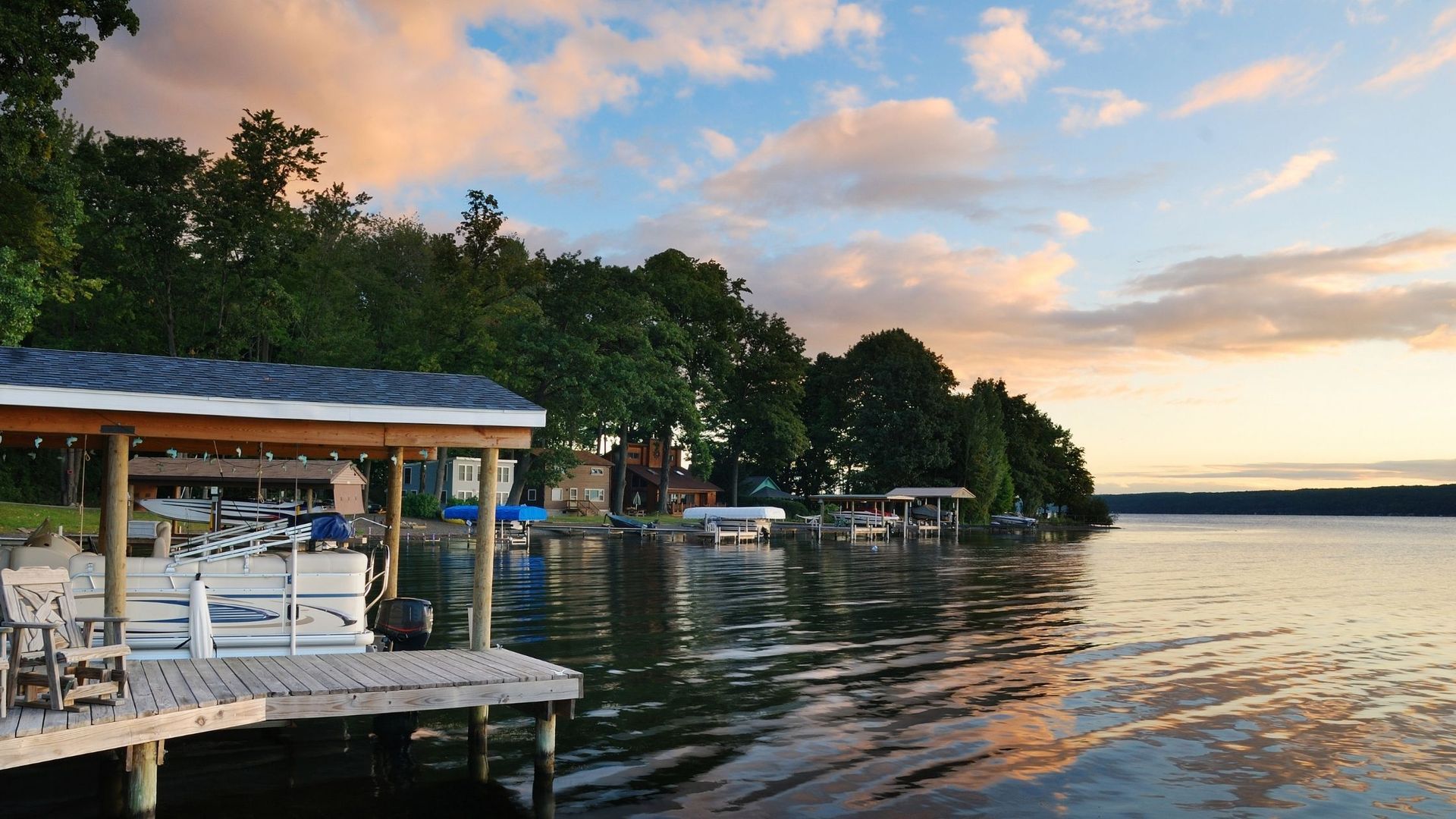 A dock on a lake with a house in the background