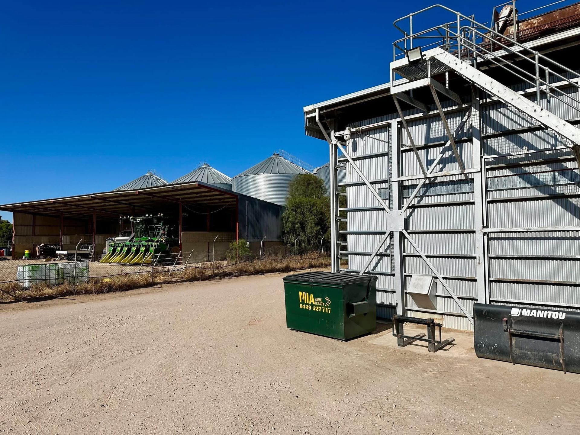 Farm bin beside silo – agricultural skip bin hire by MIA Quikskips Griffith