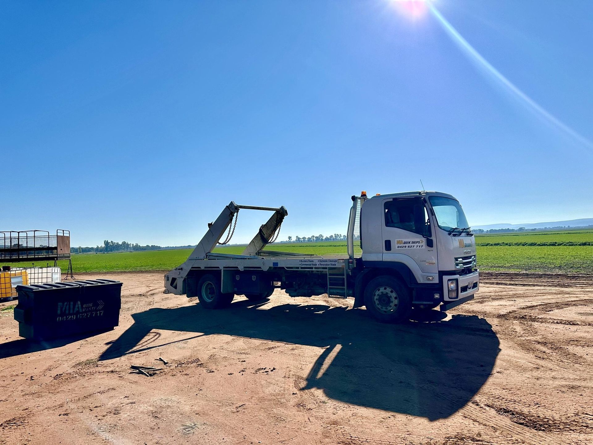 MIA Quikskips hook lift truck delivering bin to farm – rural skip bin hire Griffith NSW