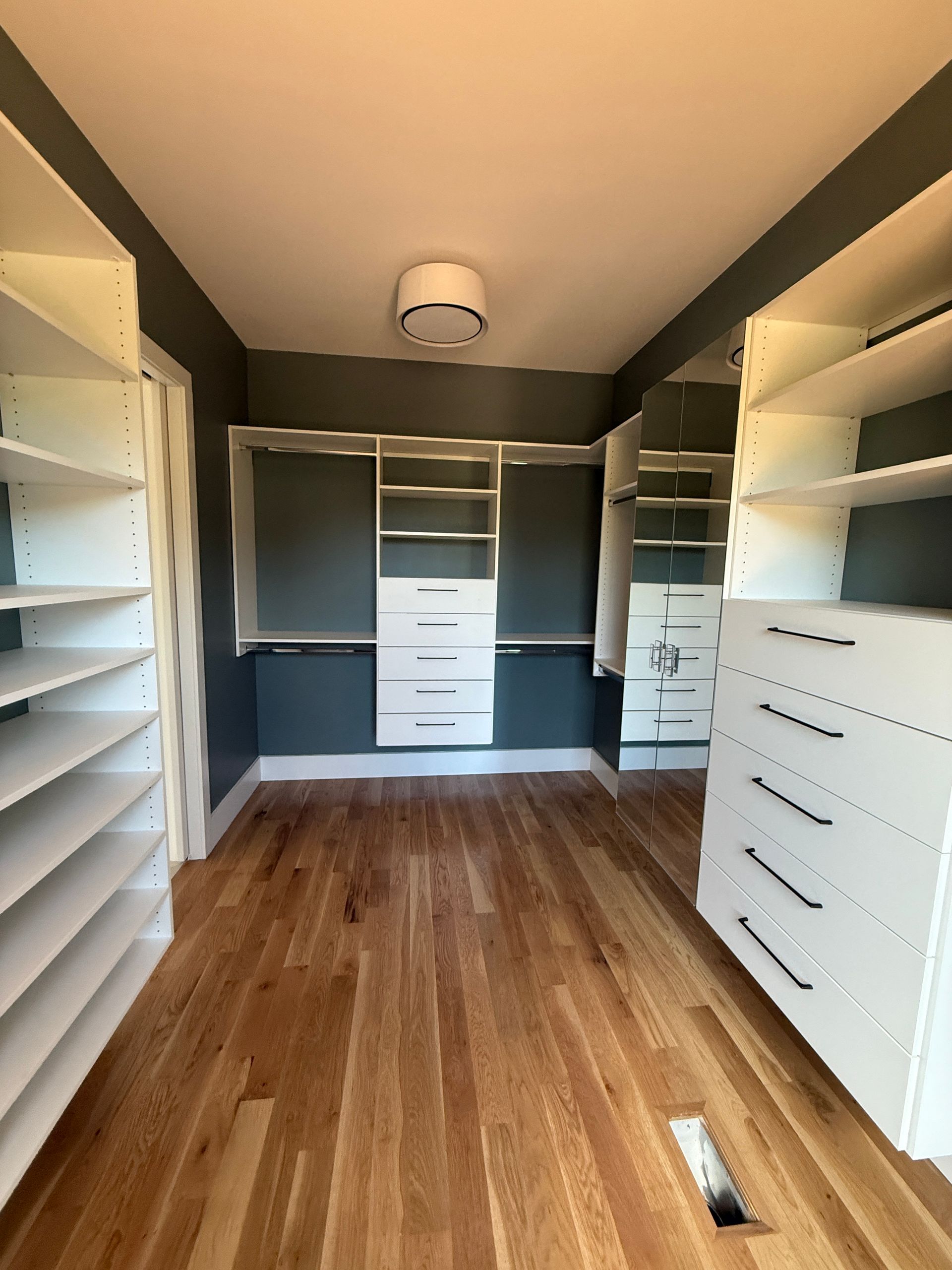 Kitchen with wood cabinets, stone backsplash, and stainless steel range hood above a black stovetop.