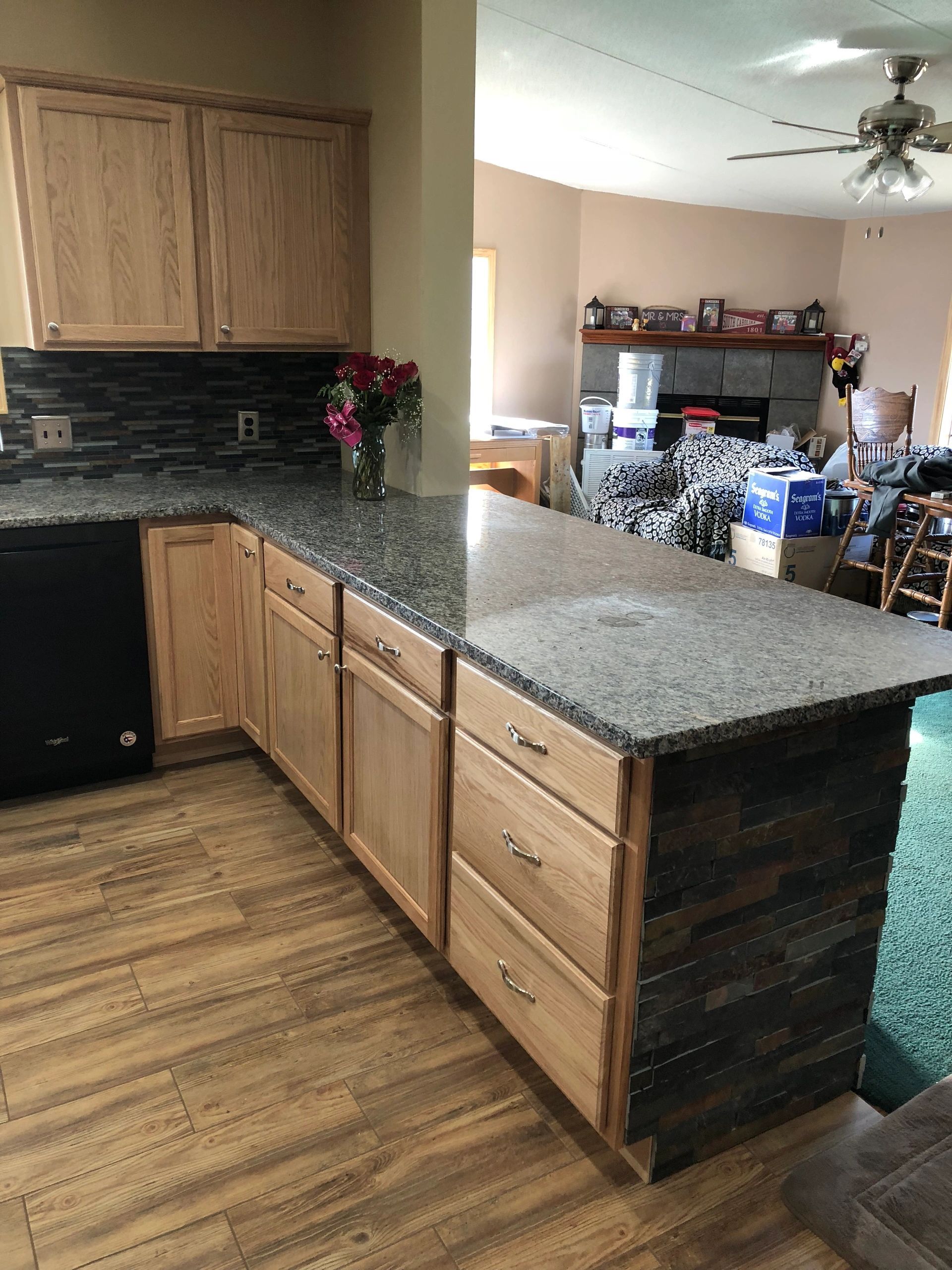 Kitchen with light wood cabinets, granite countertops, and a dark tile backsplash.