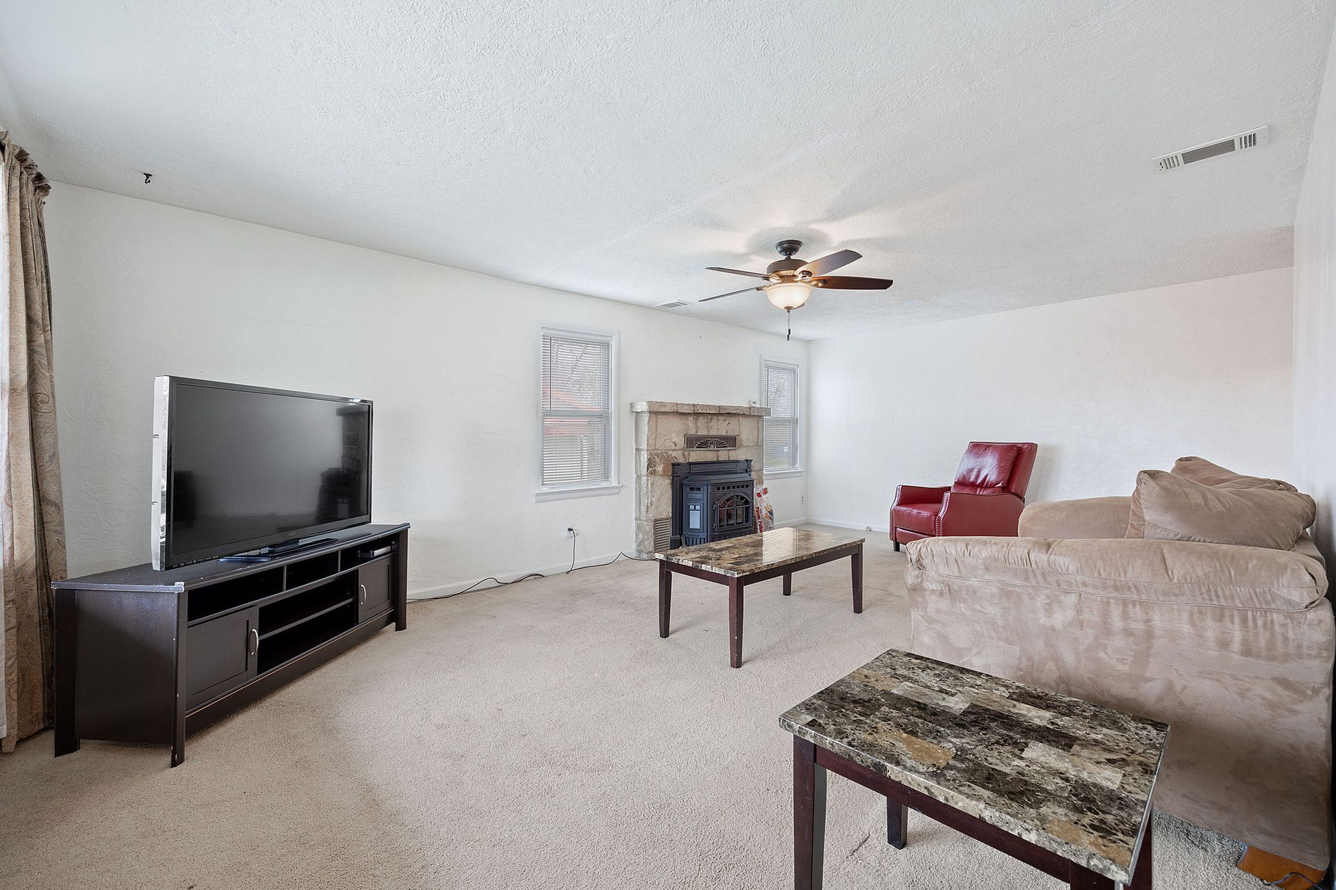 A living room with a couch , table , television and fireplace.