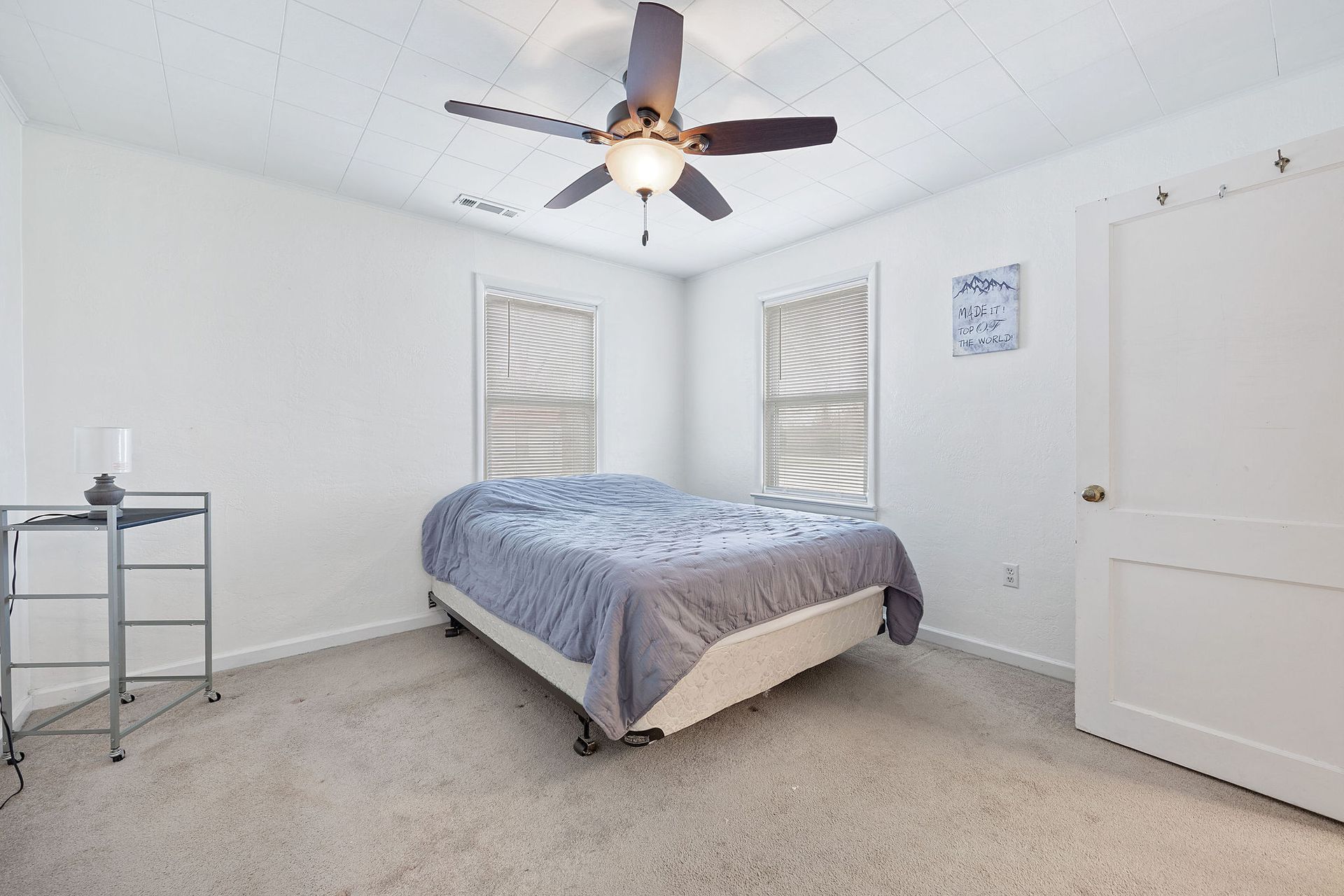 A bedroom with a bed and a ceiling fan