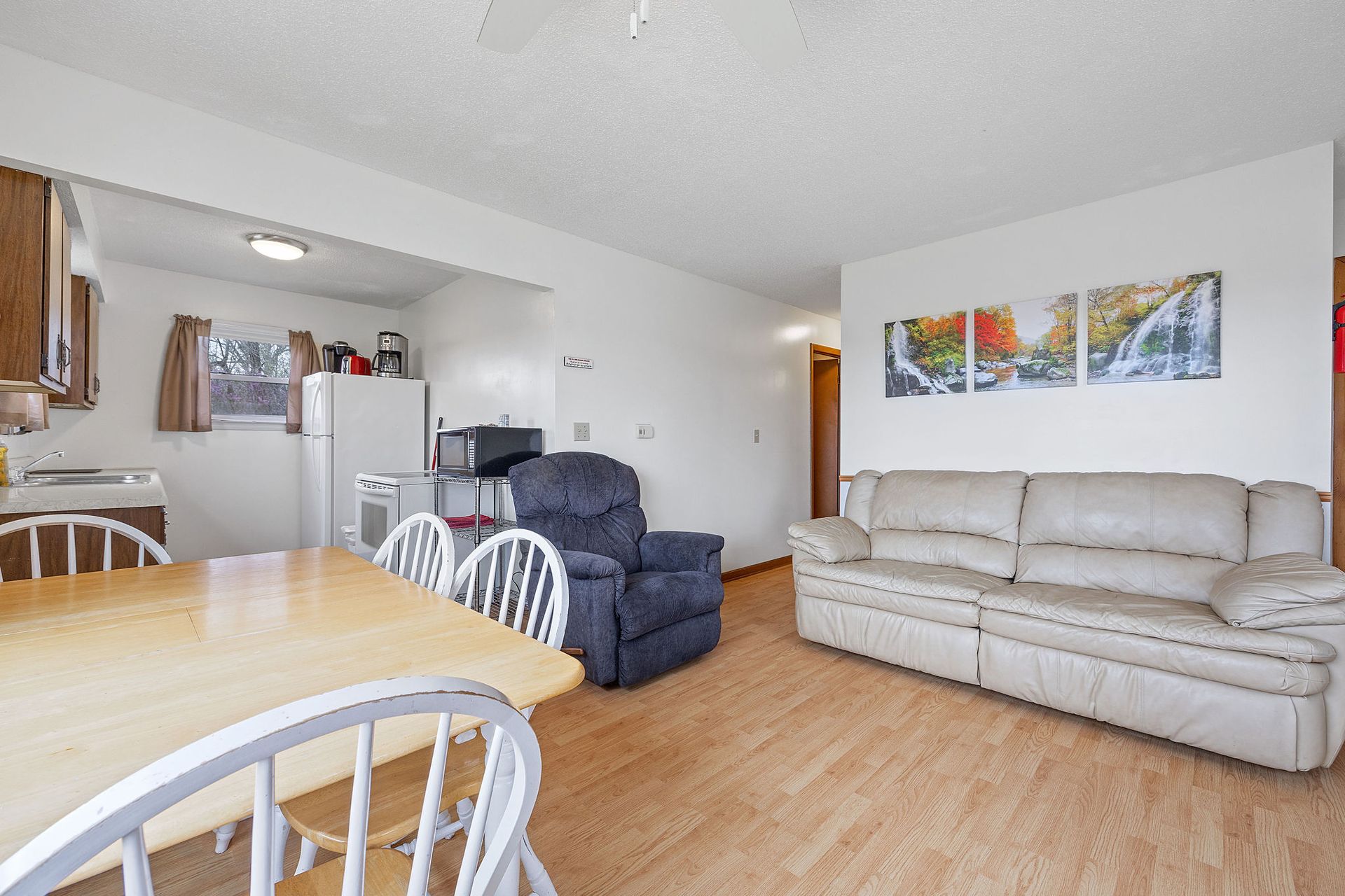 A living room with a couch , chair , table and chairs.