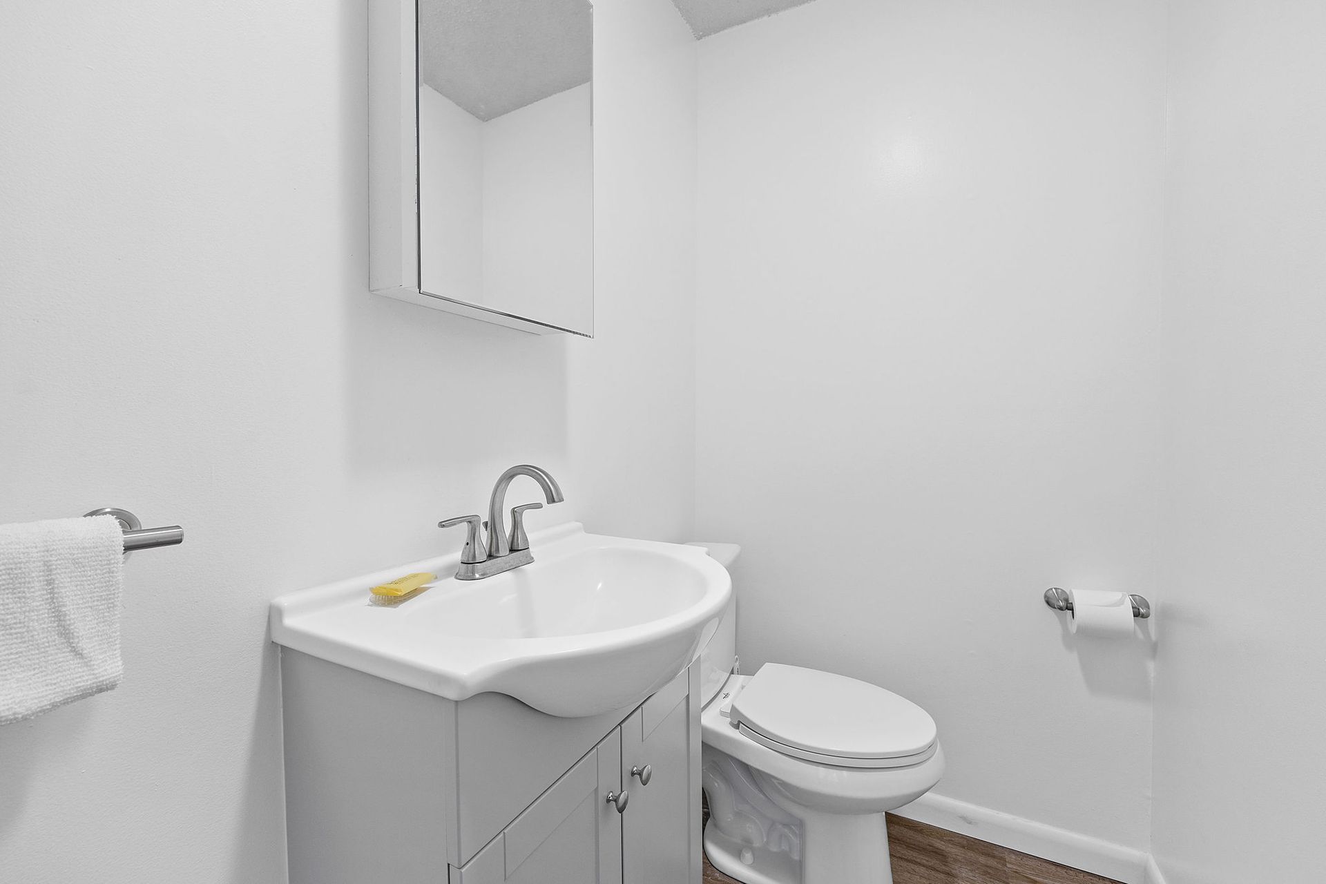 A bathroom with a sink , toilet and mirror.