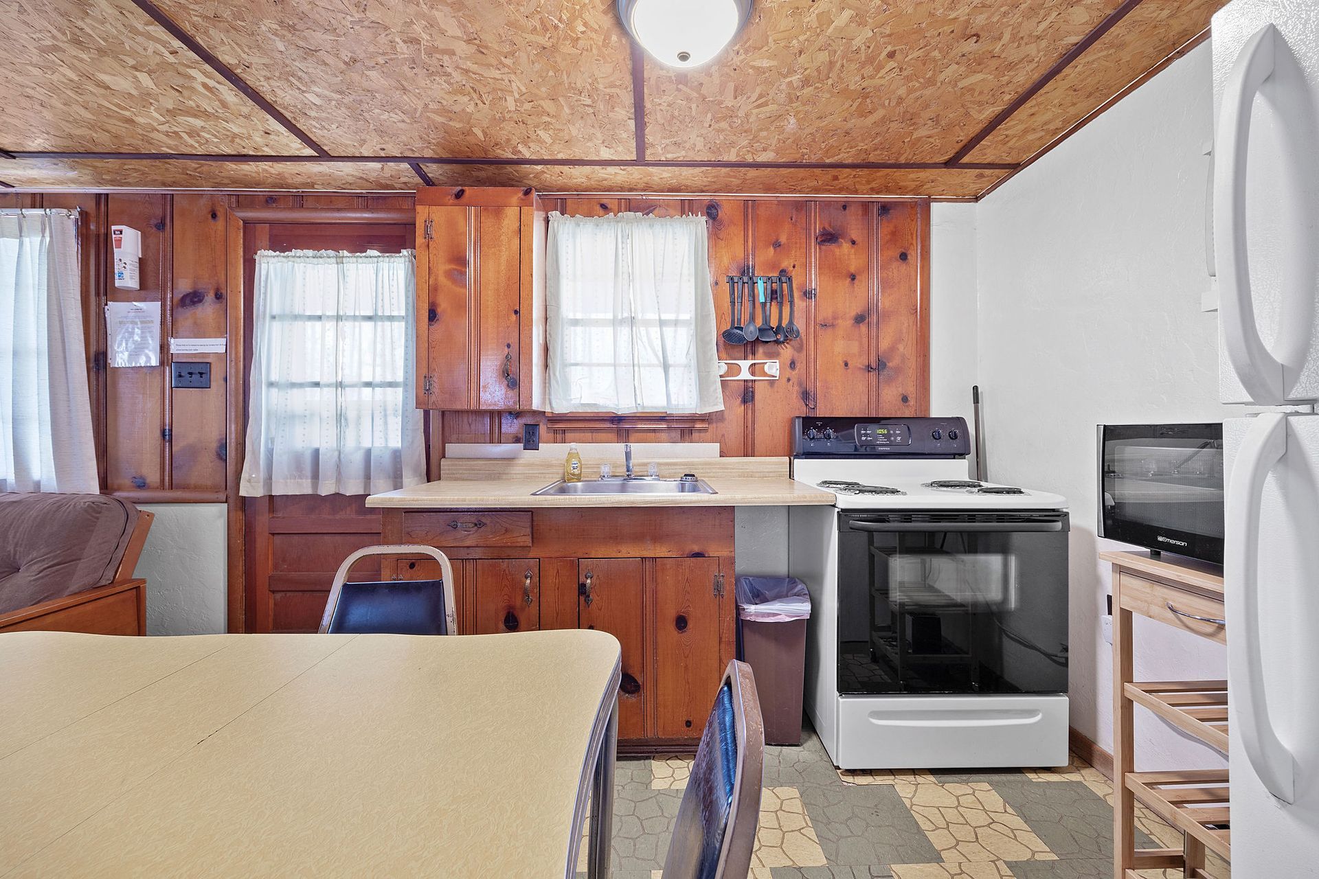 A kitchen with wooden cabinets and a white stove