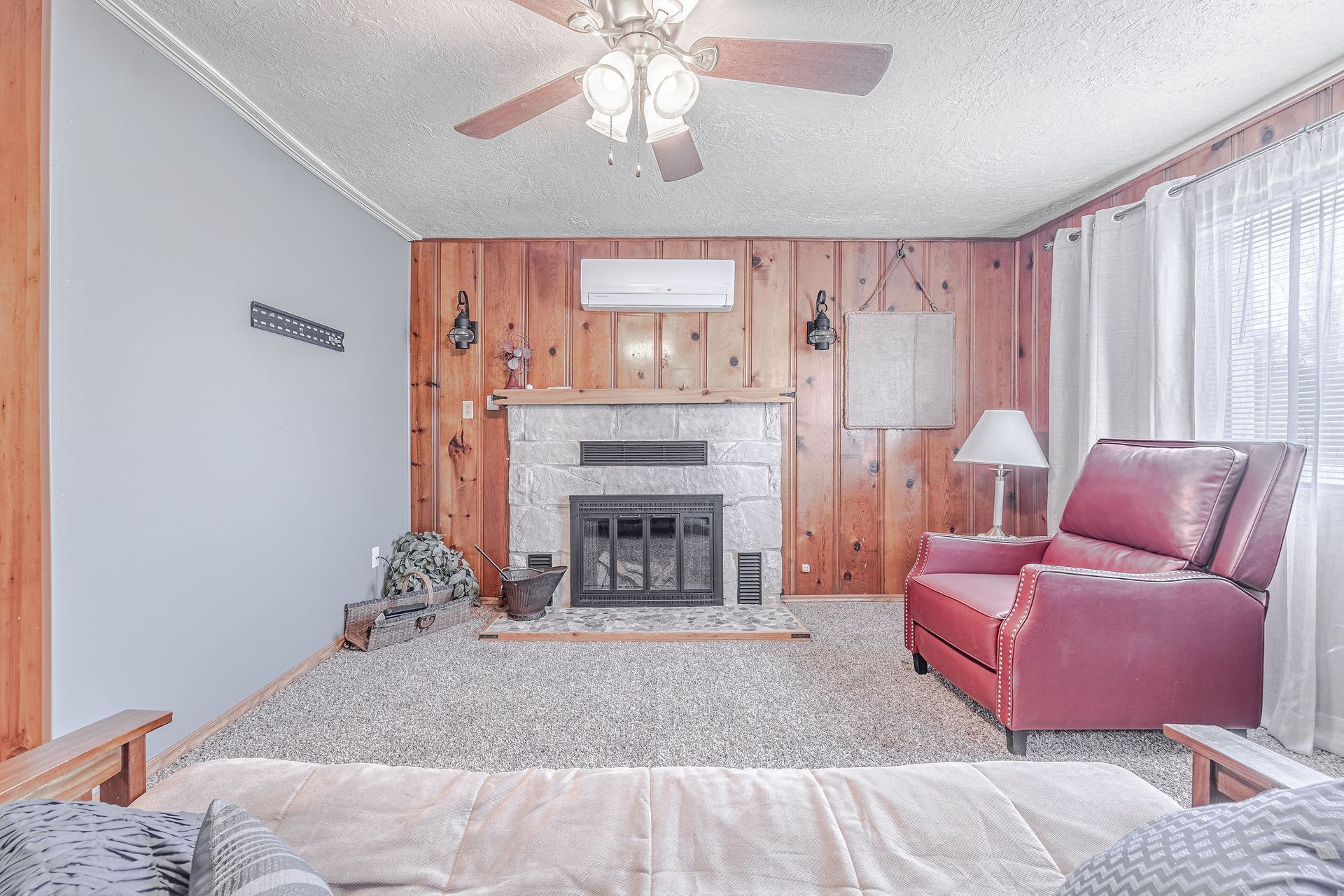 A living room with a fireplace and a ceiling fan.