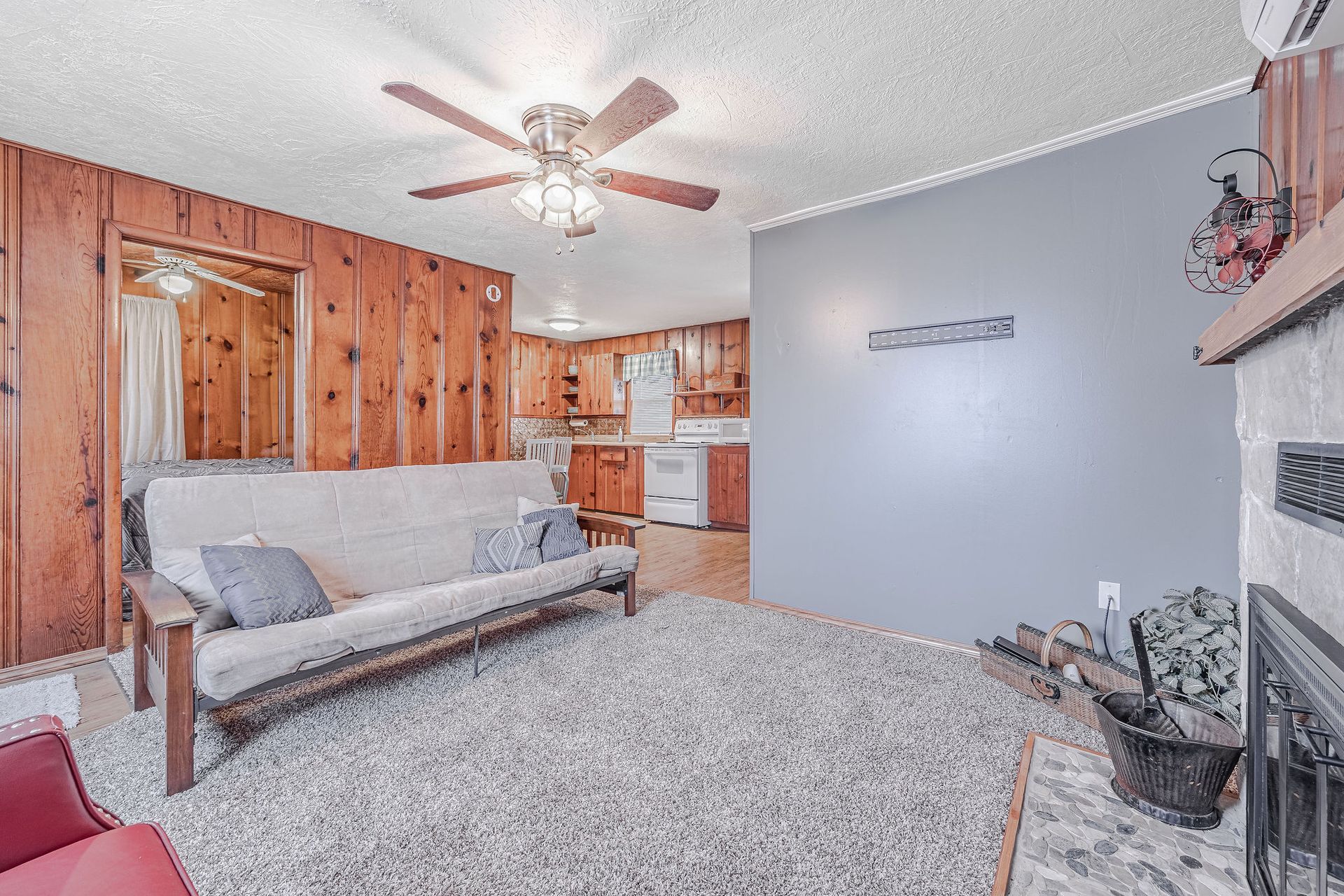 A living room with a couch , fireplace , and ceiling fan.