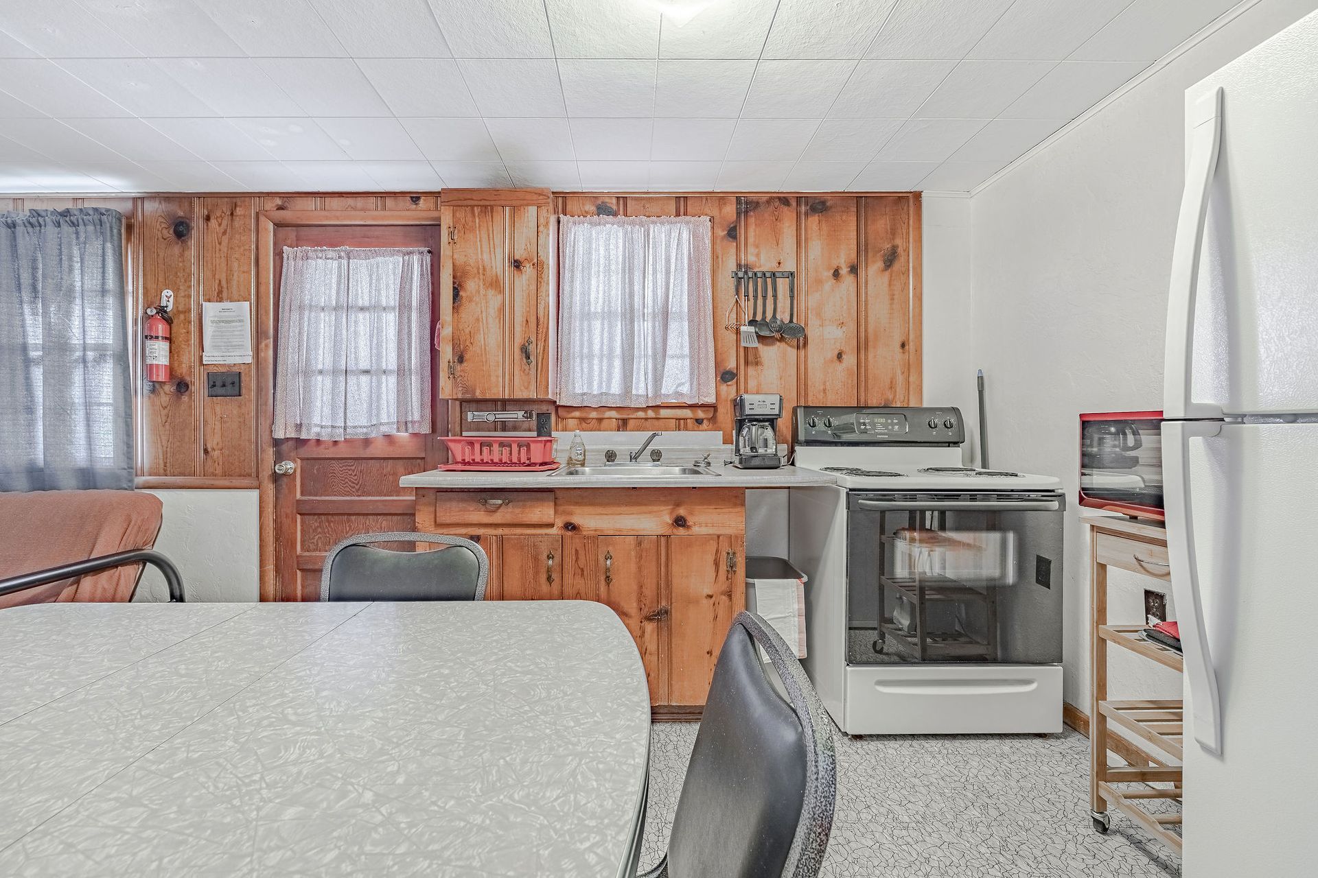 A kitchen with a table and chairs and a refrigerator