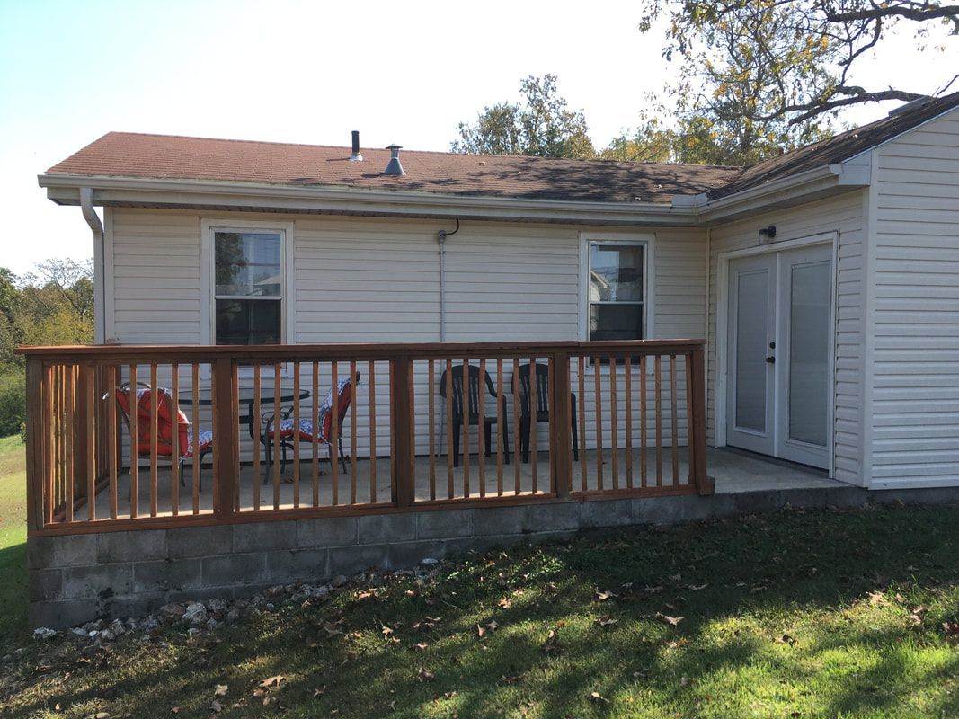 The back of a house with a deck and sliding glass doors.