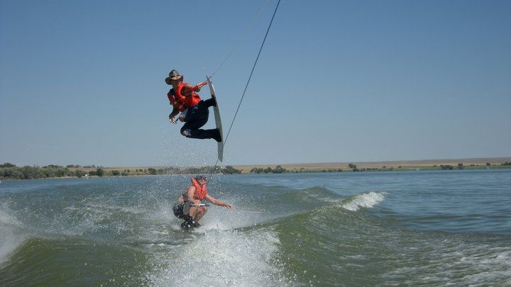 A person is riding a wave on a wakeboard in the water.