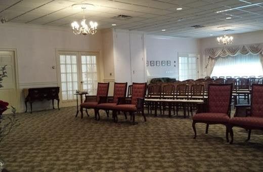A living room with a couch , chairs , and a coffin.