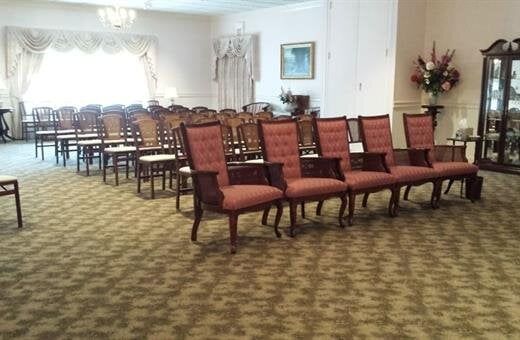 An artist 's impression of a hotel lobby with a couch , chairs , and plants.