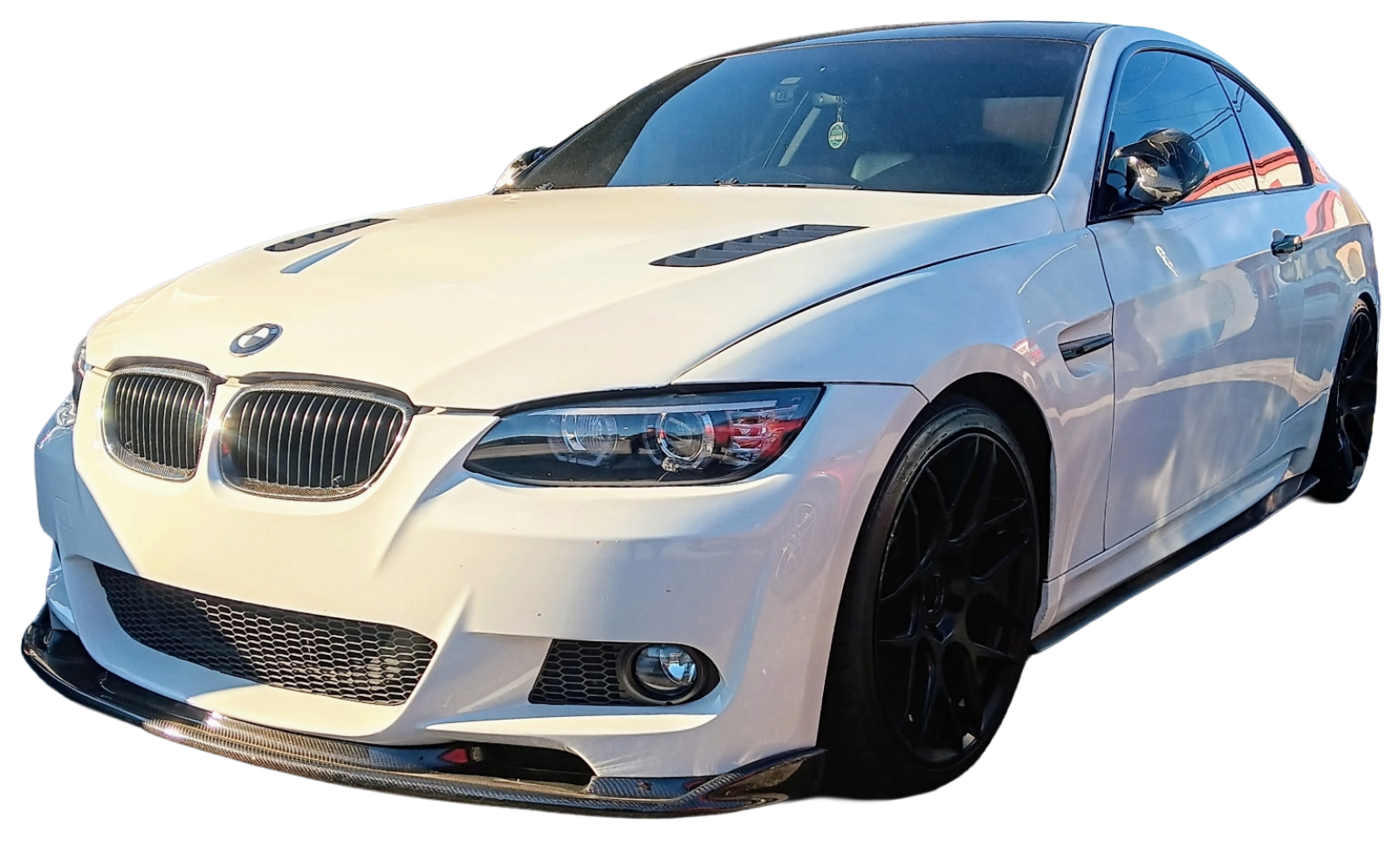 Yellow hatchback car with black wheels. White BMW coupe with black wheels, modified front bumper, and hood vents.