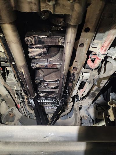 A close up of the underside of a car engine.