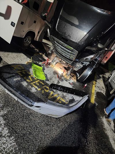 A car that has been damaged in an accident is sitting on the side of the road.
