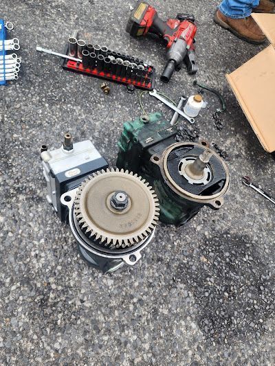 A person is working on a piece of equipment on the ground.