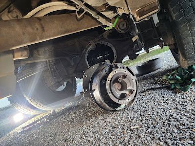 A close up of a car with a broken wheel on the ground.